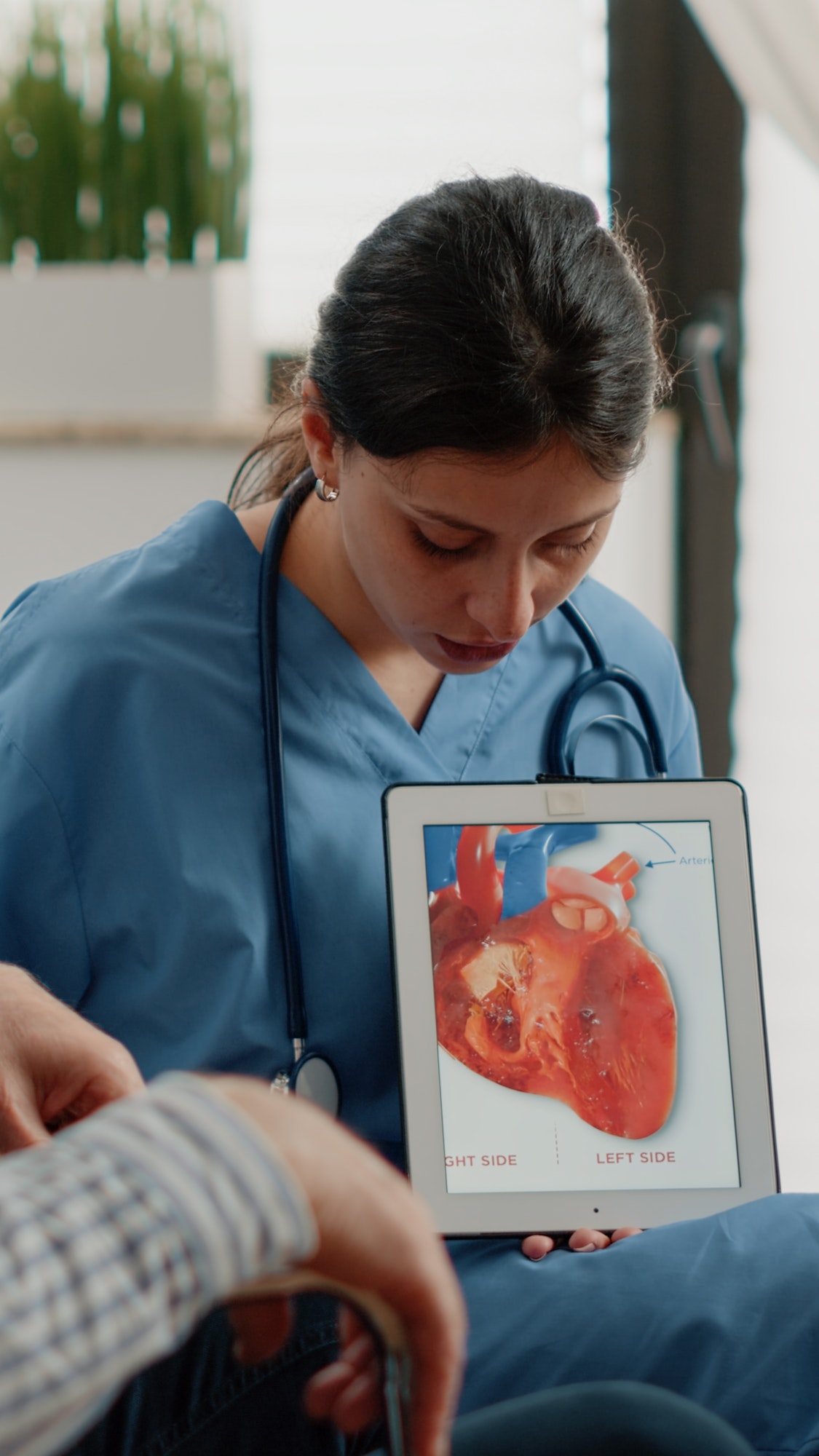 Nurse holding tablet with heart figure for cardiology diagnosis