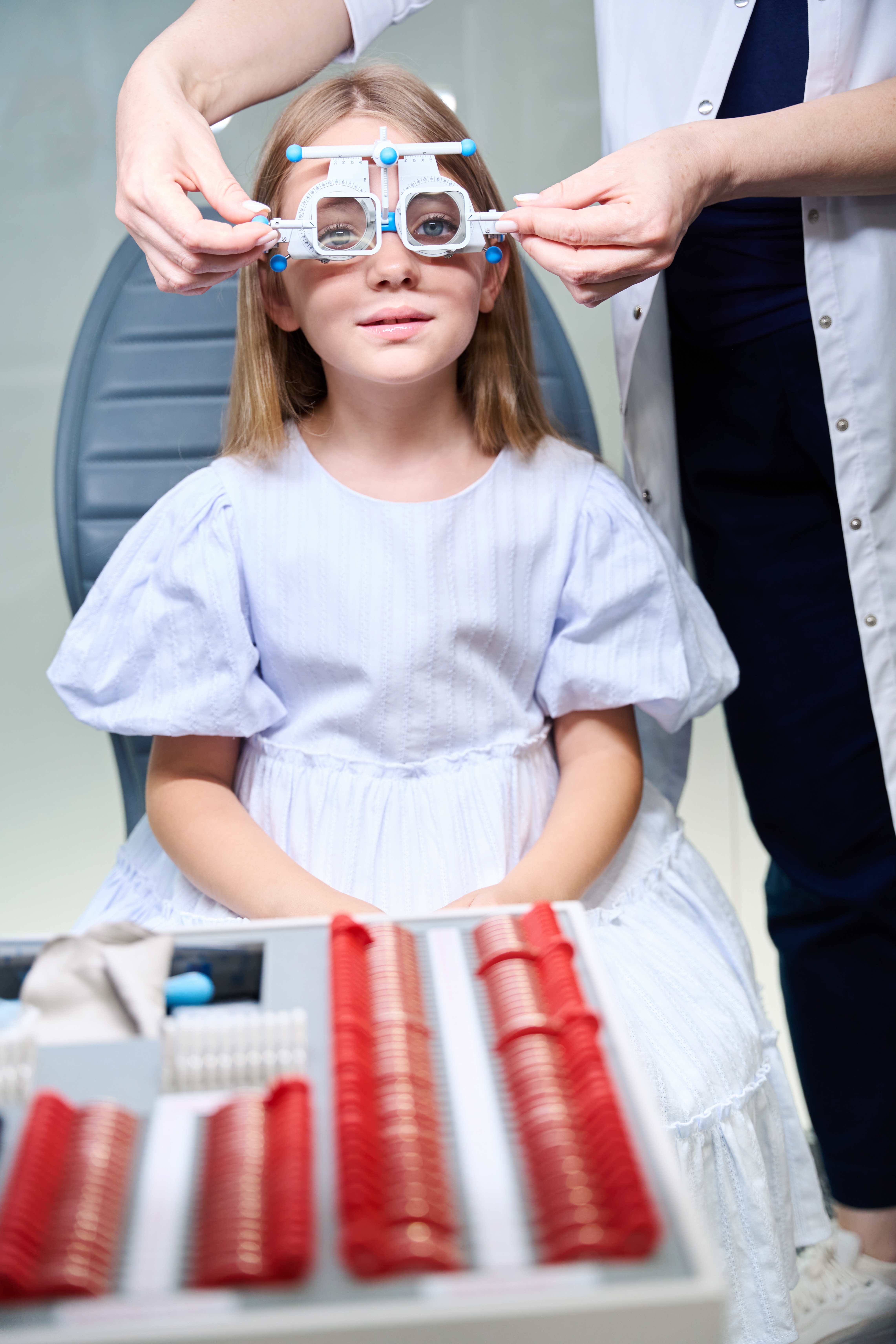 Tranquil little girl taking subjective refraction test in ophthalmologist office
